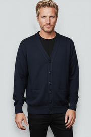 Man wearing a navy blue cardigan over a black shirt on a light gray background