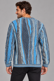A man wearing a blue and gray vertically patterned knit sweater, shown from the back against a solid gray studio background.